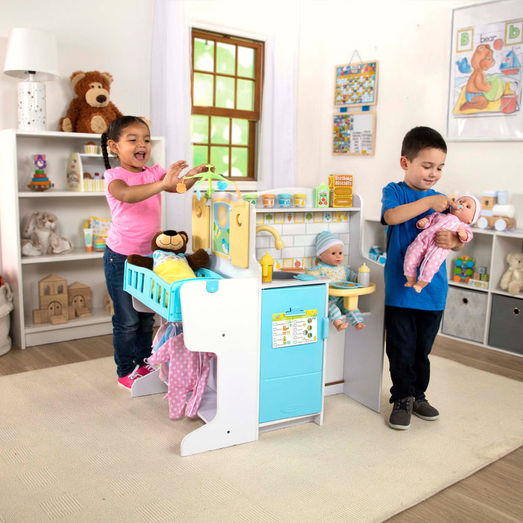 A kid playing with The Melissa & Doug Mine to Love Baby Care Activity Center for Dolls - Kitchen, Nursery, Bathing-Changing