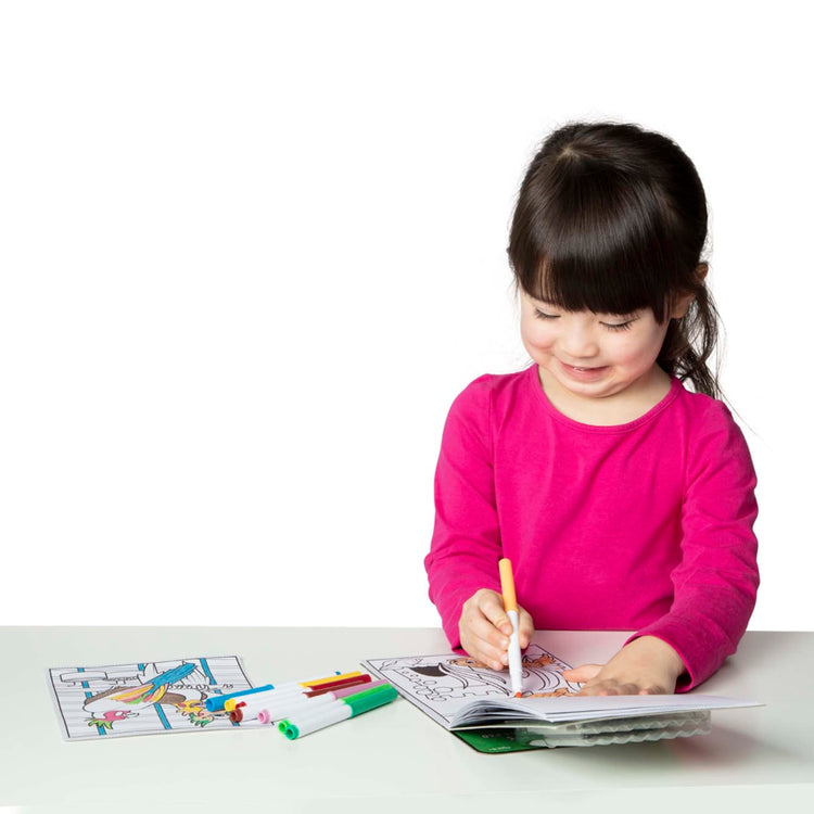 A child on white background with the Melissa & Doug Magic-Pattern Kids’ Pets Marker Coloring Pad On the Go Travel Activity